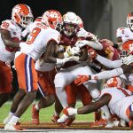 
              Iowa State running back Jirehl Brock (21), center, is stopped by a host of Clemson defenders after rushing for yardage during the first half of the Cheez-It Bowl NCAA college football game, Wednesday, Dec. 29, 2021, in Orlando, Fla. (AP Photo/Phelan M. Ebenhack)
            