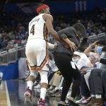 
              New Orleans Pelicans guard Devonte' Graham (4) runs into a server working court side after making a 3-pointer during the second half of an NBA basketball game against the Orlando Magic, Thursday, Dec. 23, 2021, in Orlando, Fla. (AP Photo/Phelan M. Ebenhack)
            