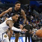 
              Denver Nuggets guard Monte Morris, left, goes after a loose ball in front of Orlando Magic guard Gary Harris during the second half of an NBA basketball game, Wednesday, Dec. 1, 2021, in Orlando, Fla. (AP Photo/John Raoux)
            