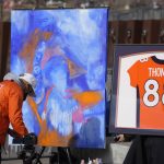 
              A man paints a picture at a memorial for Denver Broncos wide receiver Demaryius Thomas before an NFL football game between the Denver Broncos and the Detroit Lions, Sunday, Dec. 12, 2021, in Denver. Thomas died earlier this week. (AP Photo/David Zalubowski)
            
