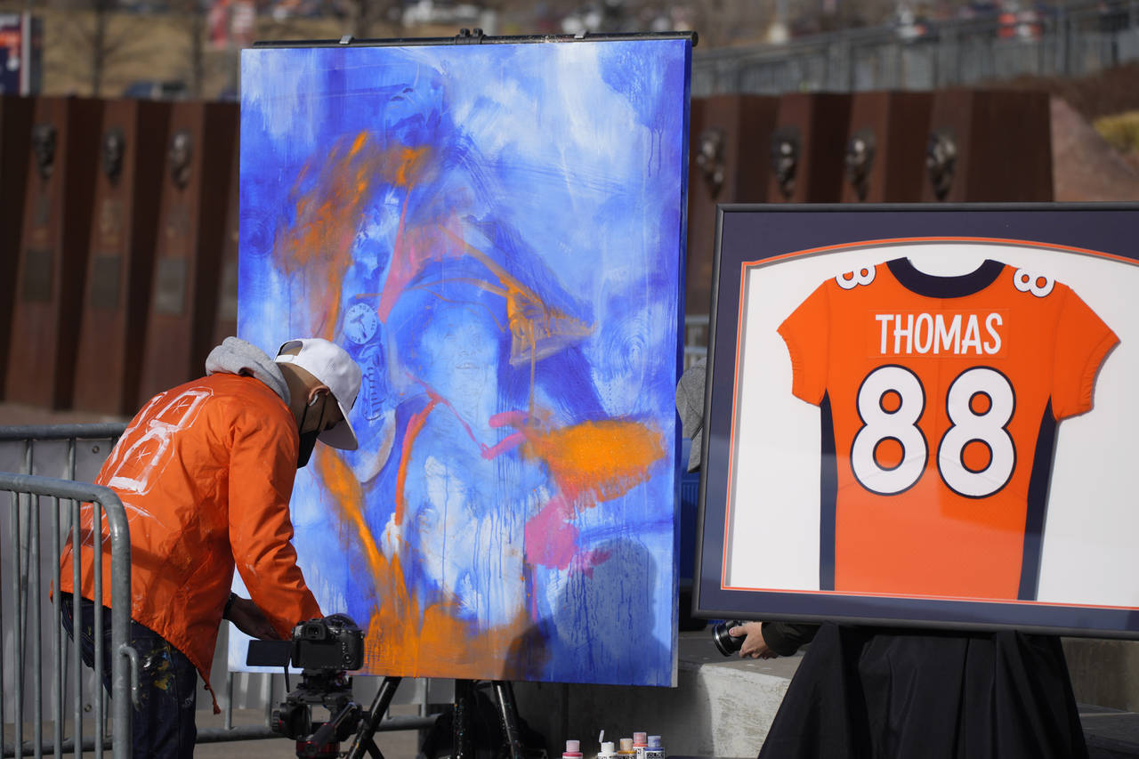 A man paints a picture at a memorial for Denver Broncos wide receiver Demaryius Thomas before an NF...