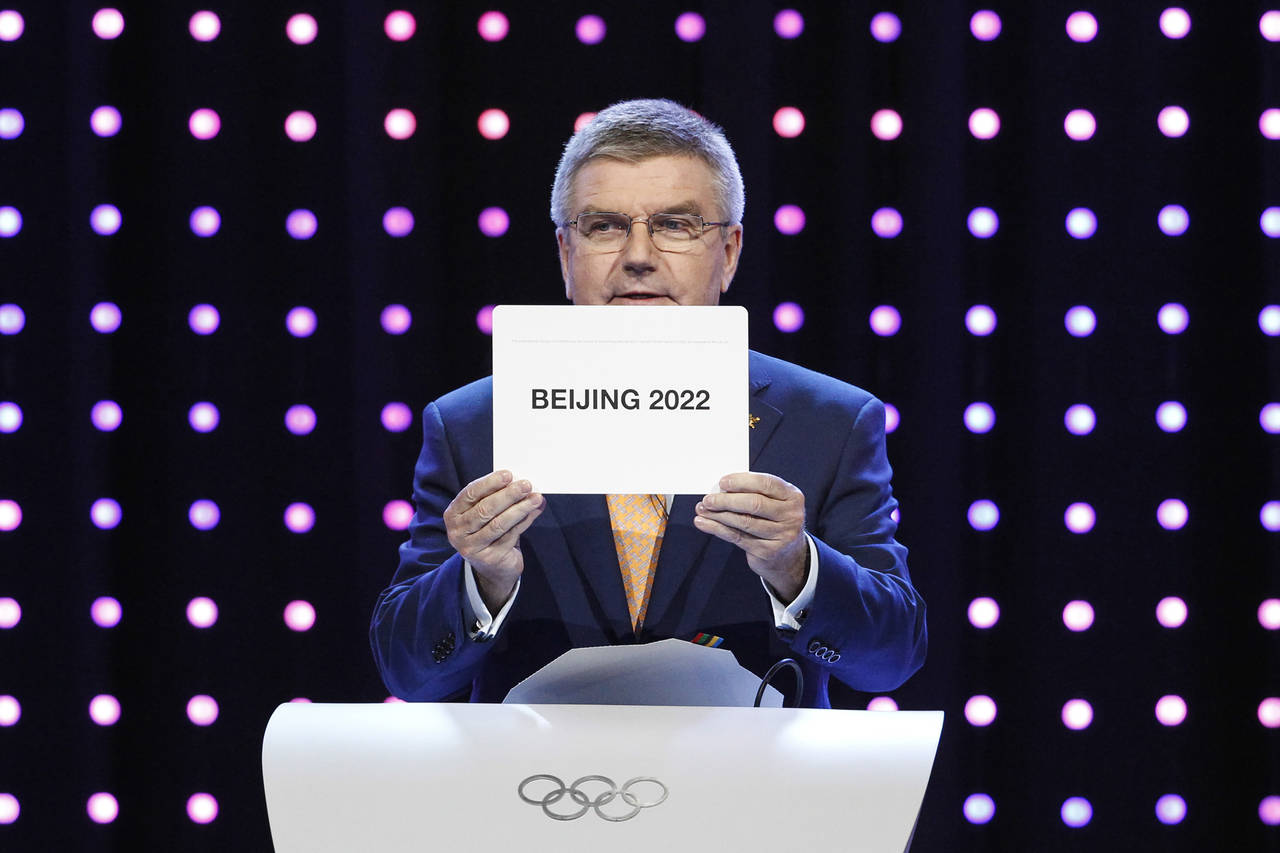 FILE - President of the International Olympic Committee (IOC) Thomas Bach opens the envelope announ...