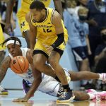 
              North Carolina forward Armando Bacot falls while chasing the ball with Michigan guard DeVante' Jones (12) during the first half of an NCAA college basketball game in Chapel Hill, N.C., Wednesday, Dec. 1, 2021. (AP Photo/Gerry Broome)
            