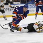 
              New York Islanders' Jean-Gabriel Pageau (44) and Vegas Golden Knights' Mattias Janmark (26) fall to the ice while chasing the puck during the first period of an NHL hockey game, Sunday, Dec. 19, 2021, in Elmont, N.Y. (AP Photo/John Munson)
            