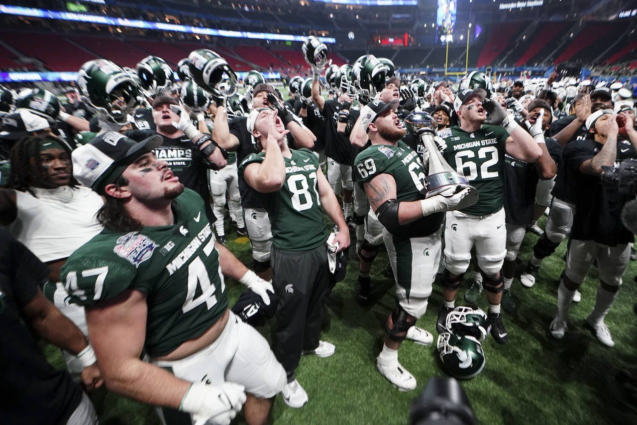 Michigan State players celebrate after the Peach Bowl NCAA college football game against Pittsburgh...