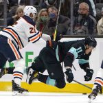 
              Seattle Kraken's Alexander True (11) tumbles in front of Edmonton Oilers' Darnell Nurse in the first period of an NHL hockey game Saturday, Dec. 18, 2021, in Seattle. (AP Photo/Elaine Thompson)
            