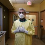 
              Steve Grove, a chaplain at Hennepin County Medical Center, prepares to enter a COVID-19 patient's room, Friday, Dec. 10, 2021, in Minneapolis. He acknowledged that he sometimes gets mad at unvaccinated patients because it "didn’t have to be this way. And now there’s a mess that perhaps was avoidable.” (AP Photo/Charlie Neibergall)
            