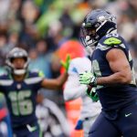 SEATTLE, WASHINGTON - JANUARY 02: Rashaad Penny #20 of the Seattle Seahawks runs the ball for a touchdown as Tyler Lockett #16 reacts during the first quarter against the Detroit Lions at Lumen Field on January 02, 2022 in Seattle, Washington. (Photo by Steph Chambers/Getty Images)