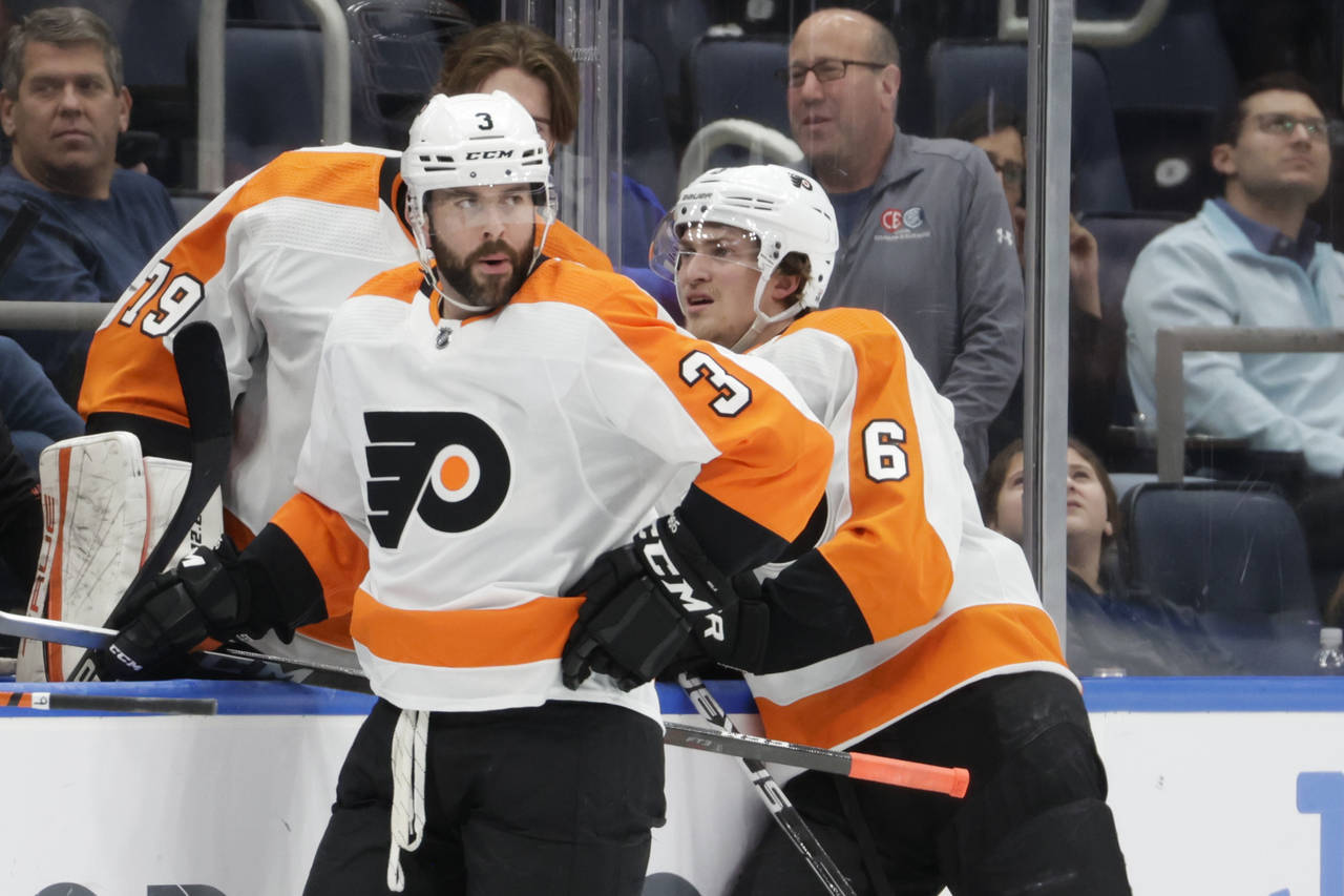 Philadelphia Flyers defensemen Keith Yandle (3) and Travis Sanheim (6) look on during a time out in...