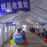 
              Residents wearing face masks to protect from the coronavirus receive a coronavirus test during a mass testing inside a tent in north China's Tianjin municipality, Sunday, Jan. 9, 2022. Tianjin, a major Chinese port city near the capital Beijing, began mass testing of its 14 million residents on Sunday, after a cluster of a dozen of children and adults tested positive for COVID-19, including a few with the omicron variant. (Chinatopix Via AP)
            