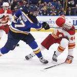 
              Calgary Flames defenseman Erik Gudbranson (44) is hit by St. Louis Blues left wing David Perron's (57) stick during the second period of an NHL hockey game Thursday, Jan. 27, 2022, in St. Louis. (AP Photo/Joe Puetz)
            