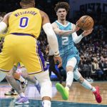 
              Charlotte Hornets guard LaMelo Ball (2) passes the ball while guarded by Los Angeles Lakers guard Russell Westbrook (0) during the first half of an NBA basketball game in Charlotte, N.C., Friday, Jan. 28, 2022. (AP Photo/Jacob Kupferman)
            
