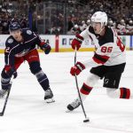 
              New Jersey Devils forward Jack Hughes, right, takes a shot in front of Columbus Blue Jackets defenseman Jake Bean during the first period of an NHL hockey game in Columbus, Ohio, Saturday, Jan. 8, 2022. (AP Photo/Paul Vernon)
            