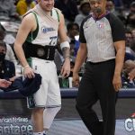 
              Dallas Mavericks guard Luka Doncic wears a black device around his waist and a wrap between his neck and right shoulder while waiting to check in to the game as referee Tony Brothers walks past in the first half of an NBA basketball game against the Memphis Grizzlies in Dallas, Sunday, Jan. 23, 2022. (AP Photo/Tony Gutierrez)
            