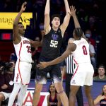 
              Washington center Riley Sorn (52) passes the ball out of a double-team by Arizona center Christian Koloko (35) and guard Bennedict Mathurin (0) during the first half of an NCAA college basketball game in Tucson, Ariz., Monday, Jan. 3, 2022. (Rebecca Sasnett/Arizona Daily Star via AP)
            