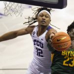 
              From left to right, TCU forward Xavier Cork (12) reaches for the ball as Baylor forward Jonathan Tchamwa Tchatchoua (23) attempts to secure a rebound in the first half of an NCAA college basketball game in Fort Worth, Texas, Saturday, Jan. 8, 2022. (AP Photo/Emil Lippe)
            