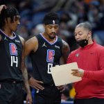 
              Los Angeles Clippers head coach Tyronn Lue goes over plays with guards Terance Mann (14) and Jay Scrubb (0) in the second half of an NBA basketball game against the New Orleans Pelicans in New Orleans, Thursday, Jan. 13, 2022. The Pelicans won 113-89. (AP Photo/Gerald Herbert)
            