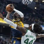 
              Indiana Pacers guard Caris LeVert (22) shoots over Boston Celtics center Robert Williams III (44) during the first half of an NBA basketball game, Wednesday, Jan. 12, 2022, in Indianapolis. (AP Photo/Darron Cummings)
            