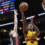 
              Atlanta Hawks forward De'Andre Hunter (12) goes up for a shot as Miami Heat guard Tyler Herro (14) defends during the first half of an NBA basketball game Wednesday, Jan. 12, 2022, in Atlanta. Hunter was playing in his first game since under going wrist surgery. (AP Photo/John Bazemore)
            