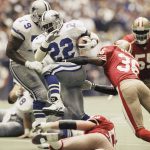 
              FILE - Dallas Cowboys running back Emmitt Smith (22) makes his way through San Francisco 49ers' defensive backs Merton Hanks (36) and Bill Romanowski (53), for a 4-yard gain in the second quarter of the Cowboy's 38-21 NFC championship win, Sunday, Jan. 23, 1994, in Irving, Texas. Few rivalries have had as many big games or star players like Roger Staubach, Joe Montana, Jerry Rice, Emmitt Smith, Deion Sanders, Steve Young, Troy Aikman and Michael Irvin. (AP Photo/Eric Gay, File)
            