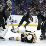
              Boston Bruins left wing Nick Foligno (17) goes down in front of Tampa Bay Lightning goaltender Andrei Vasilevskiy (88) and defenseman Cal Foote (52) after getting hurt during the first period of an NHL hockey game Saturday, Jan. 8, 2022, in Tampa, Fla. (AP Photo/Chris O'Meara)
            
