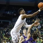 
              Oregon forward Quincy Guerrier, top, shoots over Washington forward Emmitt Matthews Jr., right, in the first half of an NCAA college basketball game in Eugene, Ore., Sunday, Jan. 23, 2022. (AP Photo/Thomas Boyd)
            