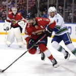 
              Florida Panthers defenseman Aaron Ekblad (5) skates with the puck as Vancouver Canucks center J.T. Miller (9) pursues during the first period of an NHL hockey game, Tuesday, Jan. 11, 2022, in Sunrise, Fla. (AP Photo/Lynne Sladky)
            