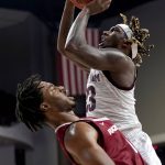 
              Texas A&M guard Tyrece Radford (23) drives to the basket as he is fouled by Arkansas guard Stanley Umude (0) during the second half of an NCAA college basketball game Saturday, Jan. 8, 2022, in College Station, Texas. (AP Photo/Sam Craft)
            
