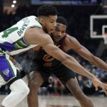 
              Milwaukee Bucks' Giannis Antetokounmpo tries to knock the ball from Cleveland Cavaliers' Evan Mobley, right, in the second half of an NBA basketball game, Wednesday, Jan. 26, 2022, in Cleveland. The Cavaliers won 115-99. (AP Photo/Tony Dejak)
            