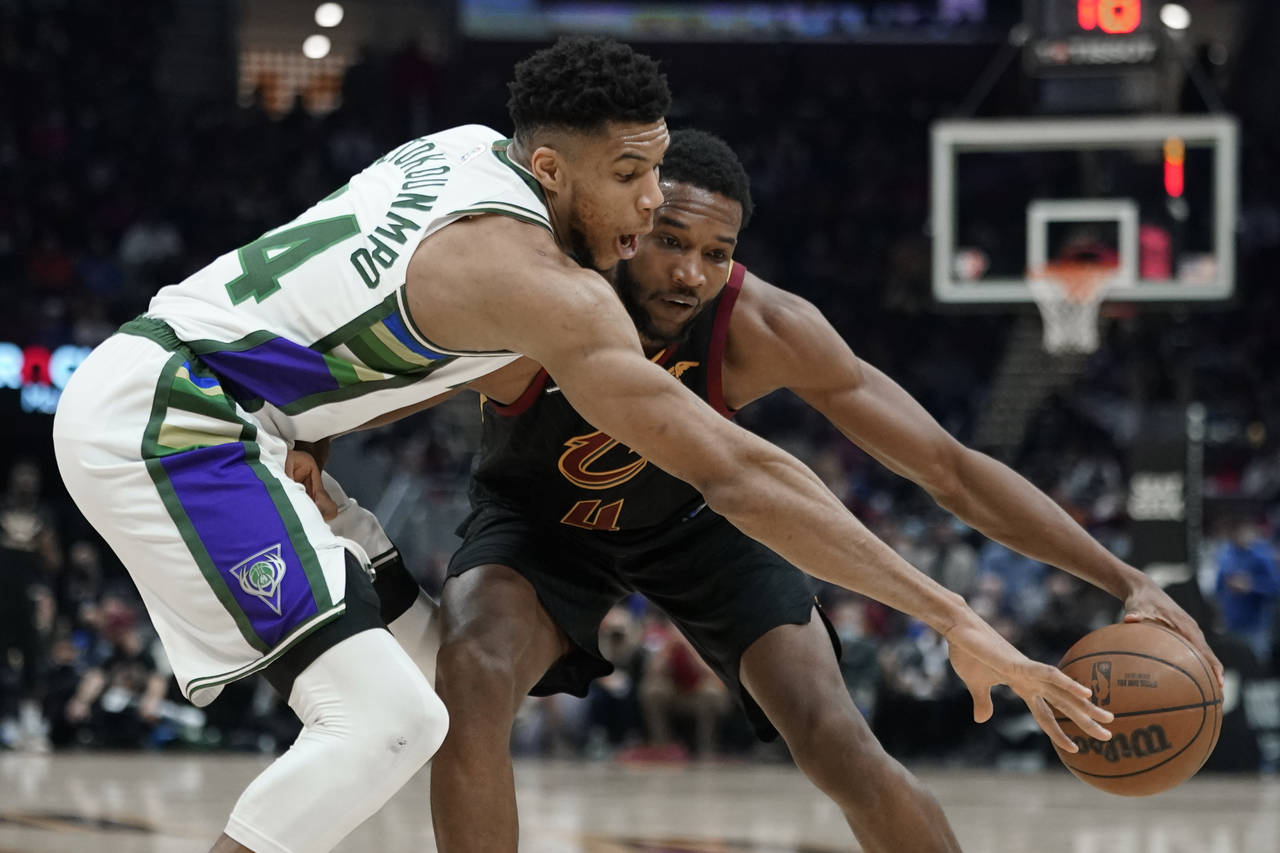 Milwaukee Bucks' Giannis Antetokounmpo tries to knock the ball from Cleveland Cavaliers' Evan Moble...