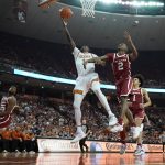 
              Texas guard Andrew Jones (1) shoots past Oklahoma guard Umoja Gibson (2) during the second half of an NCAA college basketball game, Tuesday, Jan. 11, 2022, in Austin, Texas. (AP Photo/Eric Gay)
            