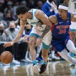 
              Charlotte Hornets guard James Bouknight and Detroit Pistons guard Justin Robinson (34) chase the ball during the second half of an NBA basketball game Wednesday, Jan. 5, 2022, in Charlotte, N.C. (AP Photo/Matt Kelley)
            