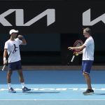 
              Defending champion Serbia's Novak Djokovic, left, talks with his coach Goran Ivanisevic during a practice session in the Rod Laver Arena ahead of the Australian Open at Melbourne Park in Melbourne, Australia, Tuesday, Jan. 11, 2022. The prime ministers of Australia and Serbia have discussed Novak Djokovic's precarious visa after the top-ranked Serbian tennis star won a court battle to compete in the Australian Open but still faces the threat of deportation because he is not vaccinated against COVID-19. (Kelly Defina/Pool Photo via AP)
            