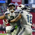 
              Seattle Seahawks quarterback Russell Wilson, left, celebrates his touchdown run against the Arizona Cardinals with Seattle Seahawks wide receiver Freddie Swain (18) during the second half of an NFL football game Sunday, Jan. 9, 2022, in Glendale, Ariz. (AP Photo/Darryl Webb)
            