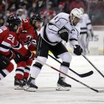 
              Los Angeles Kings center Anze Kopitar (11) passes the puck in front of New Jersey Devils defenseman Damon Severson during the first period of an NHL hockey game Sunday, Jan. 23, 2022, in Newark, N.J. (AP Photo/Adam Hunger)
            