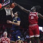 
              Michigan guard DeVante' Jones (12) has his shot blocked by Rutgers center Clifford Omoruyi (11) during the first half of an NCAA college basketball game Tuesday, Jan. 4, 2022, in Piscataway, N.J. (Andrew Mills/NJ Advance Media via AP)
            
