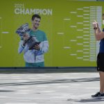 
              Visitors stop to take a photo of a billboard featuring defending champion Serbia's Novak Djokovic ahead of the Australian Open at Melbourne Park in Melbourne, Australia, Tuesday, Jan. 11, 2022. The prime ministers of Australia and Serbia have discussed Novak Djokovic's precarious visa after the top-ranked Serbian tennis star won a court battle to compete in the Australian Open but still faces the threat of deportation because he is not vaccinated against COVID-19. (AP Photo/Mark Baker)
            