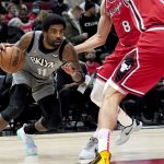 
              Brooklyn Nets' Kyrie Irving looks to drives past Chicago Bulls' Zach LaVine (8) and Nikola Vucevic during the first half of an NBA basketball game Wednesday, Jan. 12, 2022, in Chicago. (AP Photo/Charles Rex Arbogast)
            