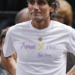 
              FILE - Staff member of Serbia's Novak Djokovic Spanish Pepe Imaz, wears a shirt that reads, "Love and Peace" as he watches the 3rd round game of the Paris Masters tennis tournament at the Bercy Arena in Paris, Nov. 3, 2016. In 2016, Djokovic teamed up with Imaz and he delved into meditation, to help calm his mind, and learned visualization techniques that he says allowed him to feel elevated above stressful situations. (AP Photo/Michel Euler, File)
            