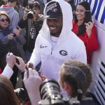 
              Georgia linebacker Nakobe Dean is greeted by a large crowd of fans as he and his teammates return to the Georgia campus, Tuesday, Jan. 11, 2022, in Athens, Ga., after defeating Alabama in the College Football Championship NCAA college football game. (AP Photo/John Bazemore)
            