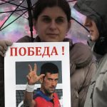 
              A woman holds up a picture of Serbia's Novak Djokovic, reading: "Victory!" during a protest in Belgrade, Serbia, Saturday, Jan. 8, 2022. The No. 1-ranked Djokovic was denied entry at the Melbourne airport late Wednesday after border officials canceled his visa for failing to meet its entry requirement that all non-citizens be fully vaccinated for COVID-19. (AP Photo/Darko Vojinovic)
            
