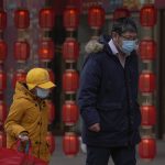 
              A man and a child wearing face masks to help protect from the coronavirus walk by a lantern decoration on display outside a mall in Beijing, Sunday, Jan. 23, 2022. Chinese authorities have called on the public to stay where they are during the Lunar New Year instead of traveling to their hometowns for the year's most important family holiday. (AP Photo/Andy Wong)
            