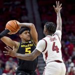 
              Missouri guard Jarron Coleman (5) tries to drive past Arkansas guard Davonte Davis (4) during the second half of an NCAA college basketball game Wednesday, Jan. 12, 2022, in Fayetteville, Ark. (AP Photo/Michael Woods)
            