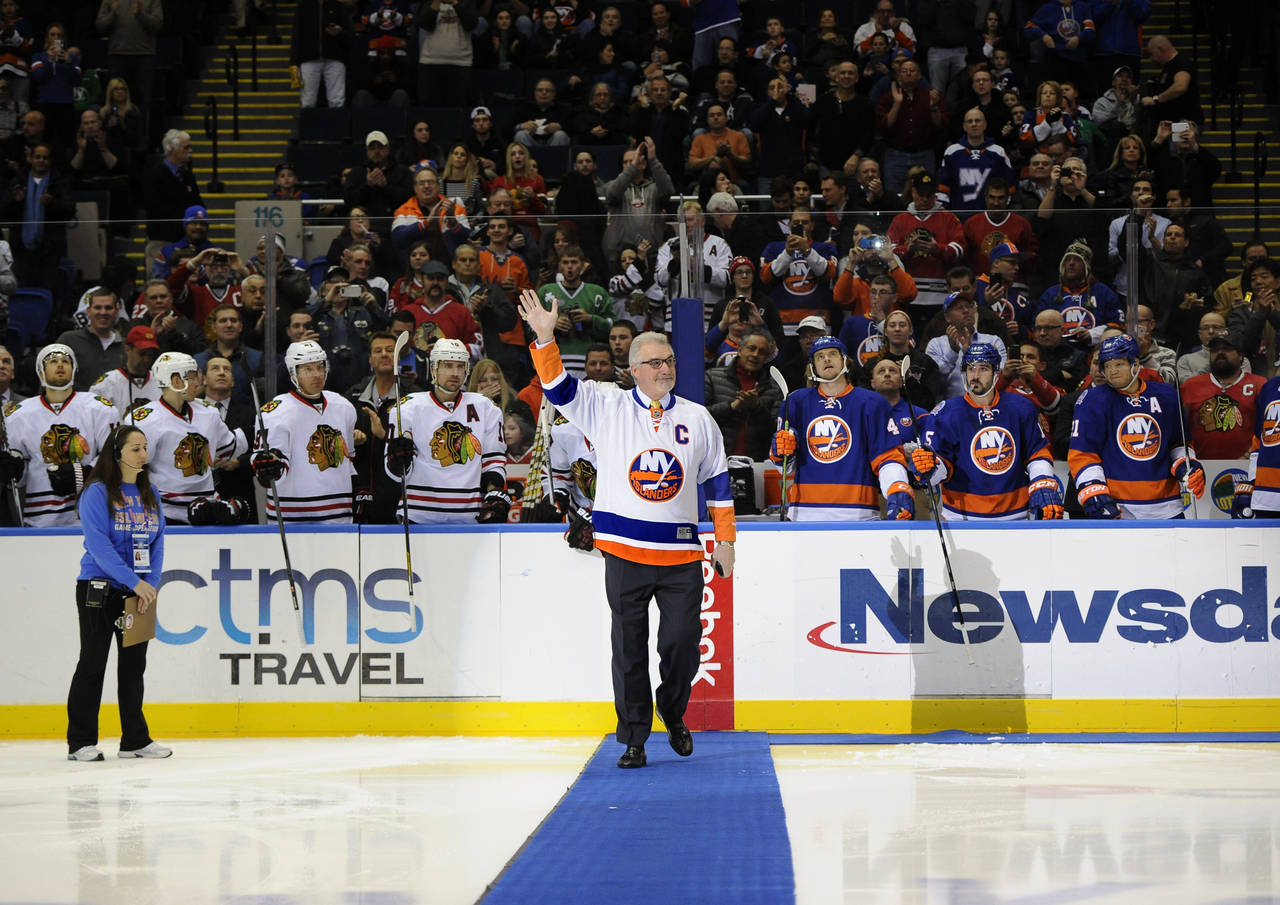FILE - Former New York Islander Clark Gillies waves to fans before he dropped a ceremonial puck bef...