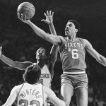 
              FILE - Philadelphia's Julius Erving (6) goes to the basket past Milwaukee's Sidney Moncrief and Brian Winters (32) during first quarter NBA playoff action in Milwaukee on May 2, 1982. (AP Photo/File)
            