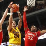 
              Minnesota guard Sean Sutherlin (24) shoots between Ohio State forwards Kyle Young (25) and E.J. Liddell (32) in the first half of an NCAA college basketball game Thursday, Jan. 27, 2022, in Minneapolis. (AP Photo/Bruce Kluckhohn)
            