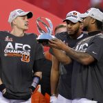 
              Cincinnati Bengals quarterback Joe Burrow, left, celebrates with teammates as they hold the Lamar Hunt trophy after the AFC championship NFL football game against the Kansas City Chiefs, Sunday, Jan. 30, 2022, in Kansas City, Mo. The Bengals won 27-24 in overtime. (AP Photo/Paul Sancya)
            