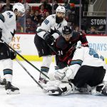 
              Carolina Hurricanes' Seth Jarvis (24) tries to jam the puck past San Jose Sharks goaltender James Reimer (47) with Sharks' Jaycob Megna (24) and Brent Burns (88) during the second period of an NHL hockey game in Raleigh, N.C., Sunday, Jan. 30, 2022. (AP Photo/Karl B DeBlaker)
            