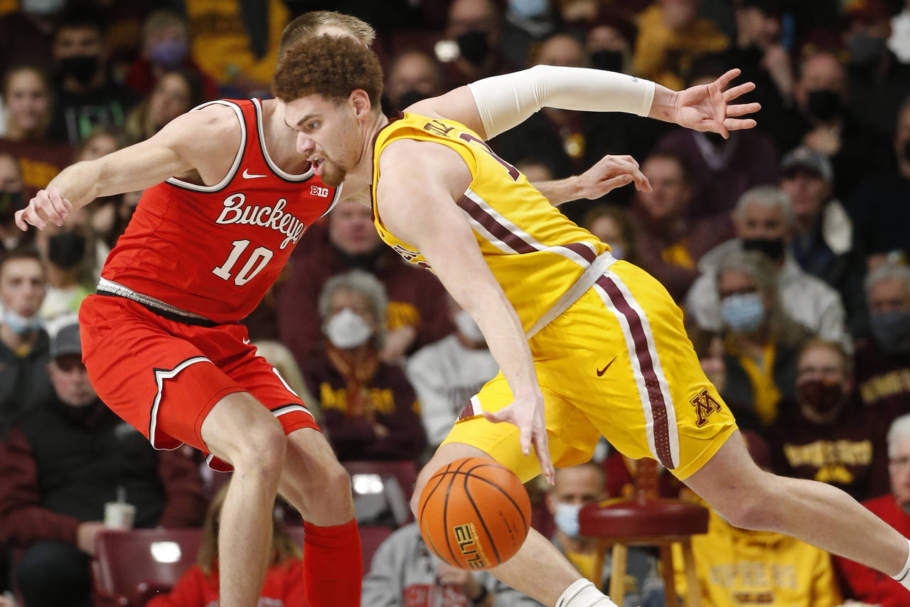 Minnesota forward Jamison Battle, right, drives past Ohio State forward Justin Ahrens (10) in the s...