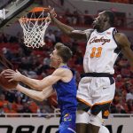 
              Kansas guard Christian Braun, left, goes to the basket in front of Oklahoma State forward Moussa Cisse (33) in the second half of an NCAA college basketball game Tuesday, Jan. 4, 2022, in Stillwater, Okla. (AP Photo/Sue Ogrocki)
            